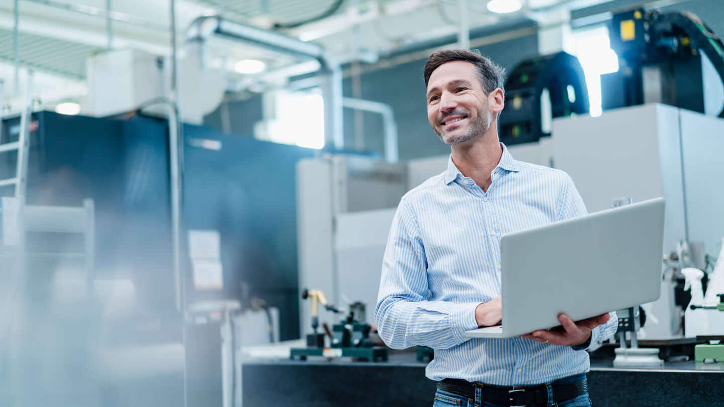 Businessman holding laptop while working in industry