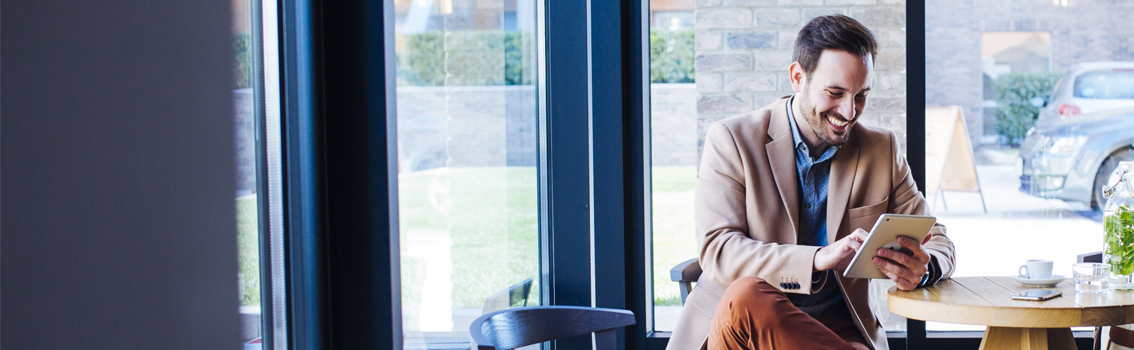 man smiling looking at tablet